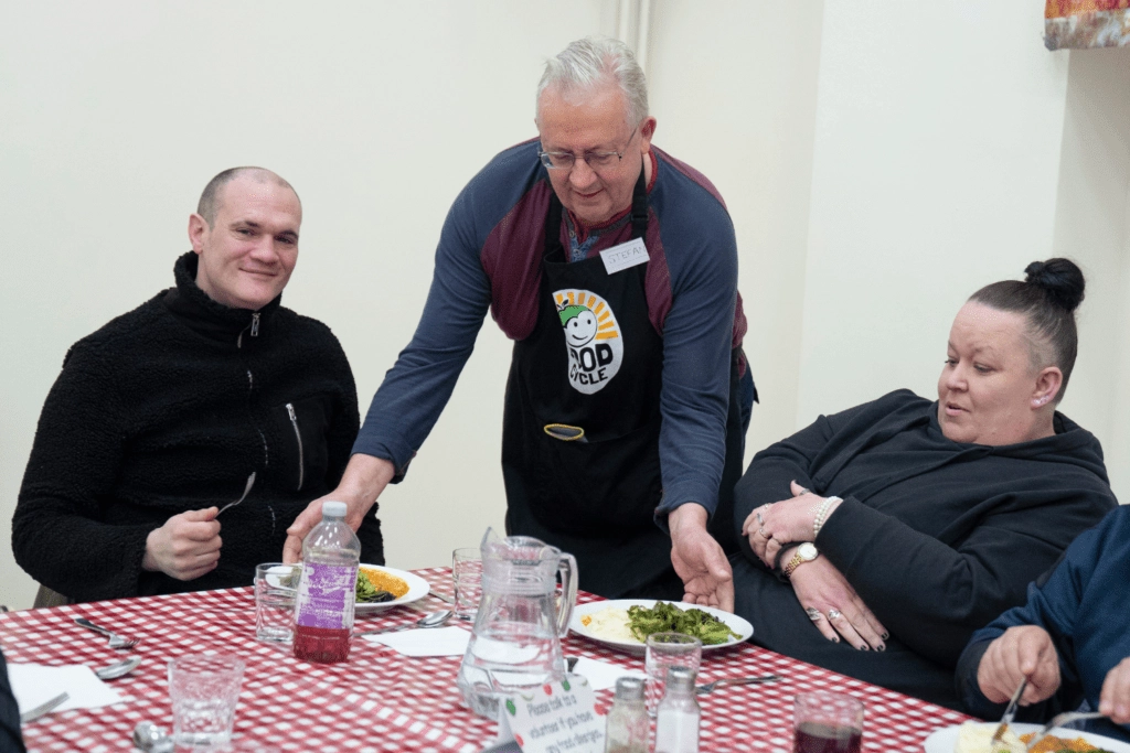 Man serving food to people on table